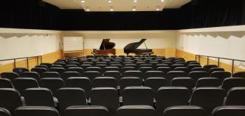 The David Alpert Lecture Hall, with two open pianos.