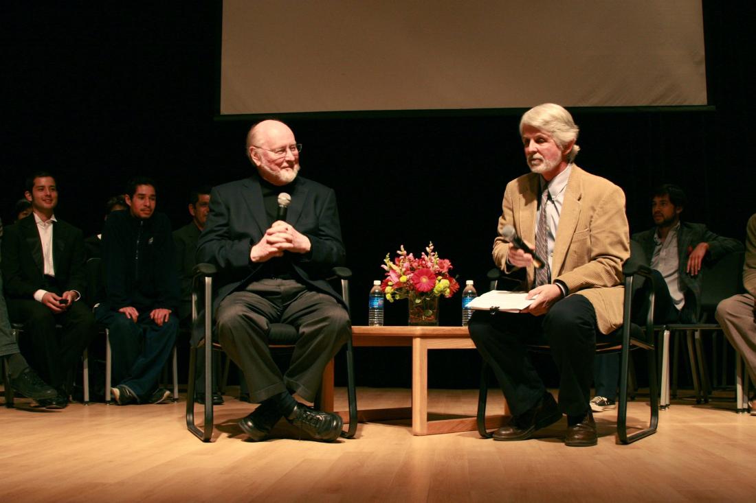 John Williams and Professor Dutton on Stage with Other People in the Background.