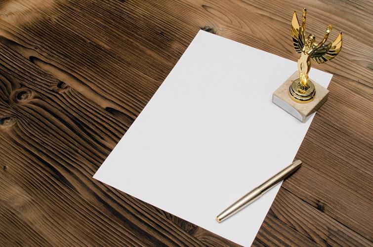Paper w/ pen and award
