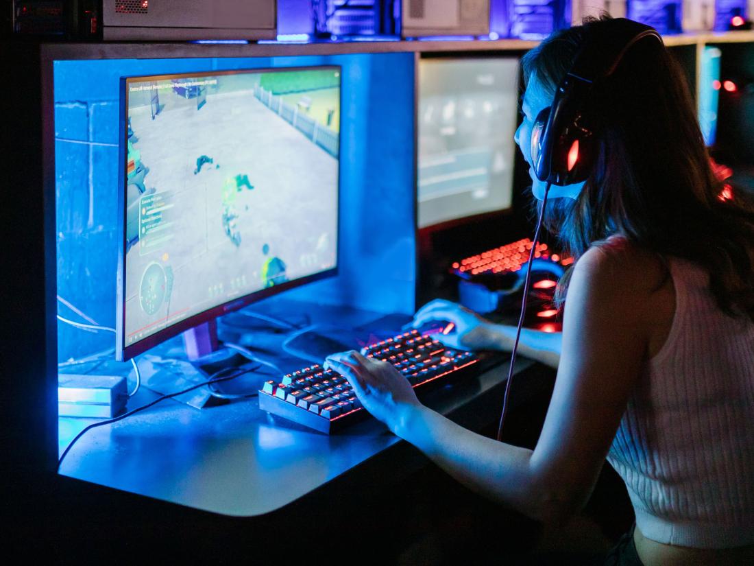 Girl playing video games on desk.